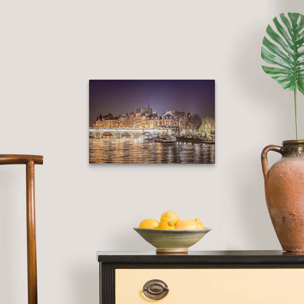 A traditional room featuring A photograph of Paris from the Seine river at night.
