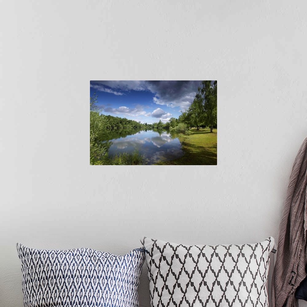 A bohemian room featuring Tranquil landscape in summer by the water. Sky with big clouds