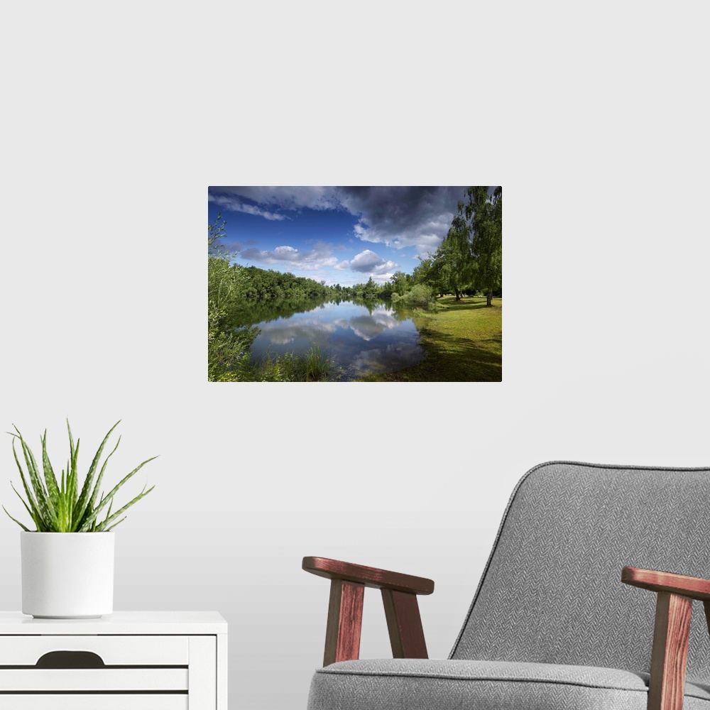 A modern room featuring Tranquil landscape in summer by the water. Sky with big clouds