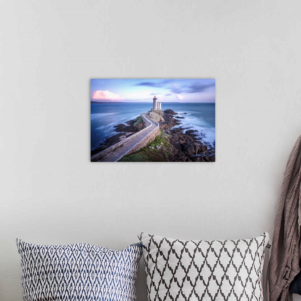 A bohemian room featuring Fine art photo of a lighthouse at the end of a rocky peninsula in France.