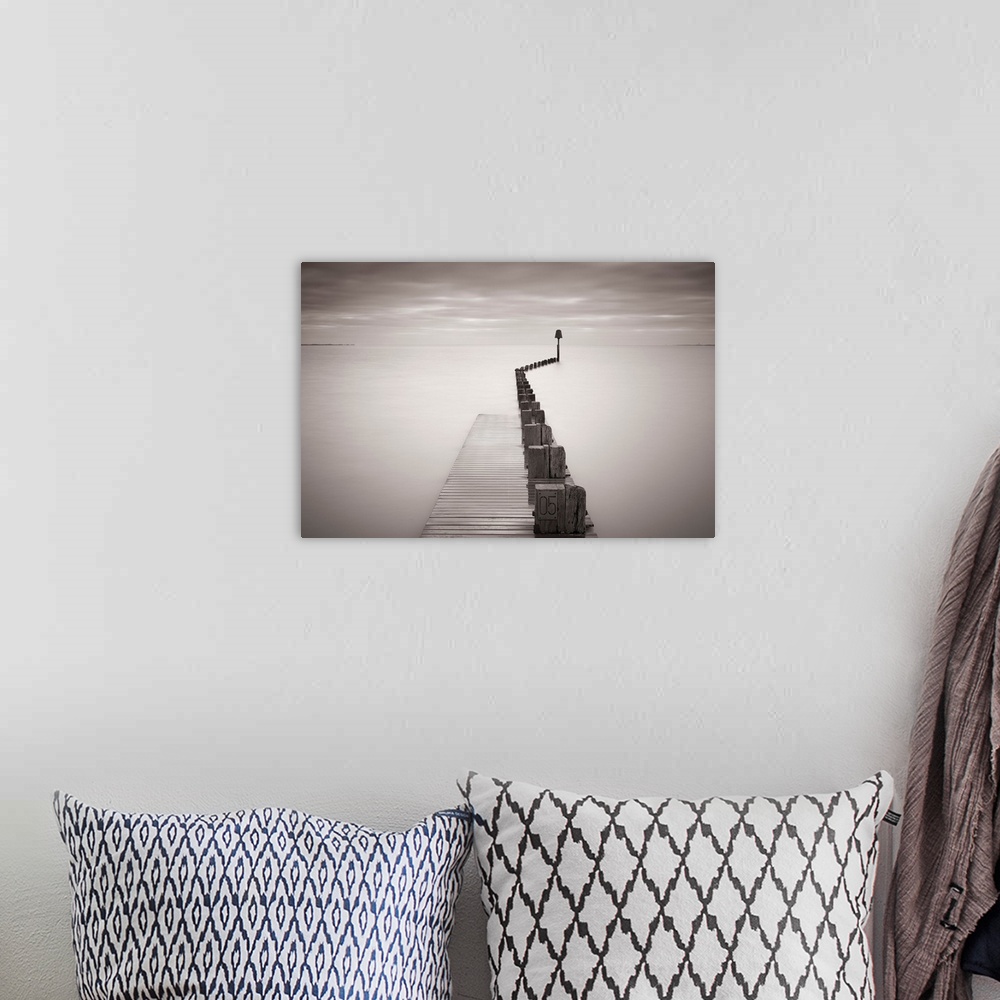 A bohemian room featuring Photograph of dock stretching into ocean under a cloudy sky.