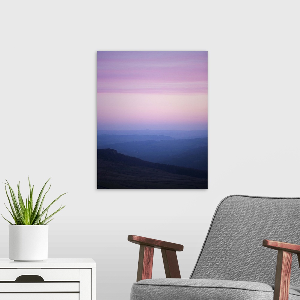 A modern room featuring A photograph of a silhouetted hazy landscape under a sunset sky.