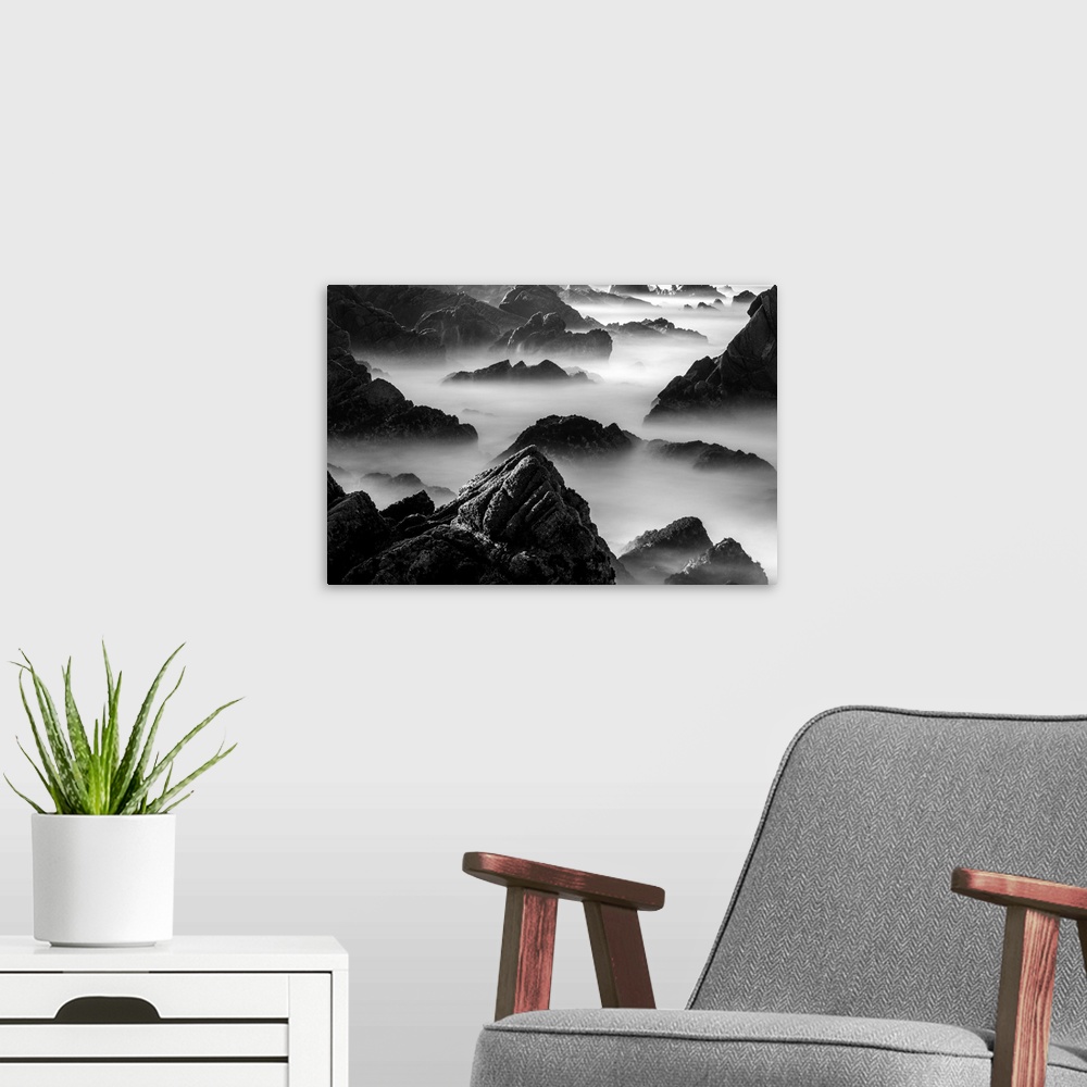 A modern room featuring Rocky outcroppings rising above the mist on the coast in Point Lobos, California.