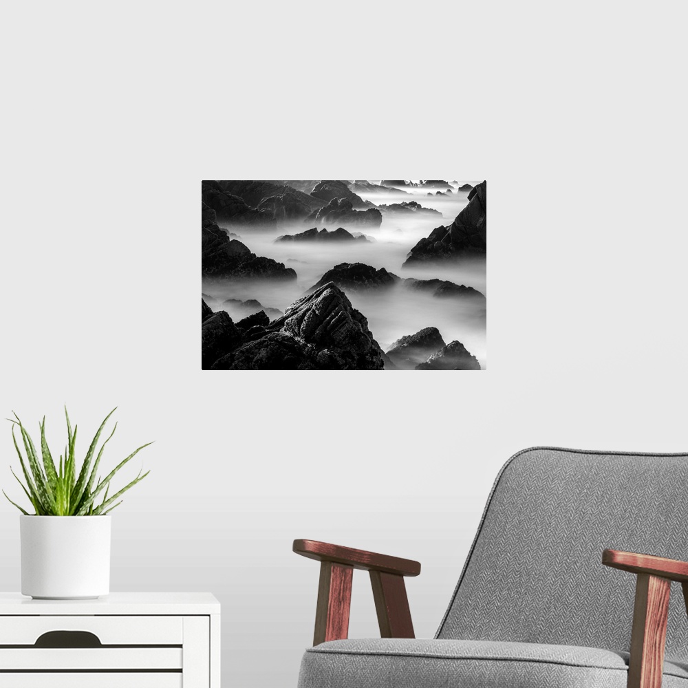 A modern room featuring Rocky outcroppings rising above the mist on the coast in Point Lobos, California.