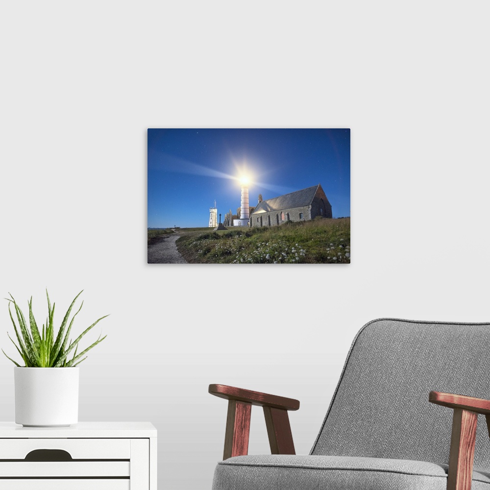 A modern room featuring Light shining from the lighthouse on the Bretagne coast in France.