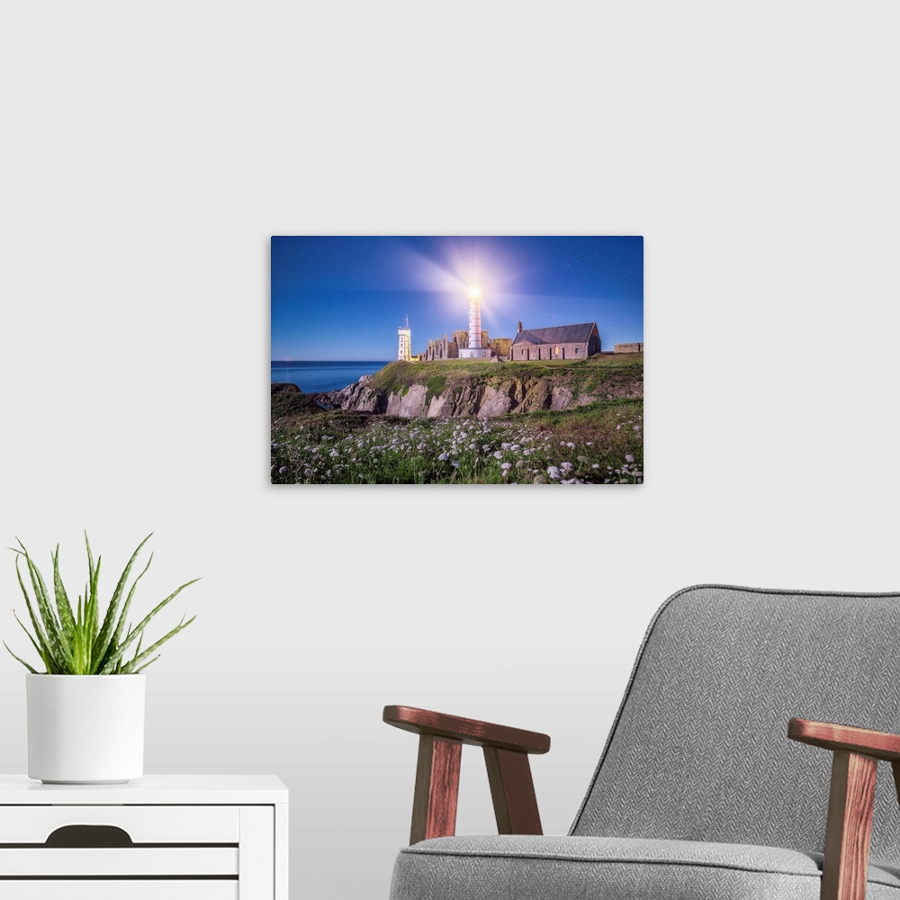 A modern room featuring Light shining from the lighthouse on the Bretagne coast in France.