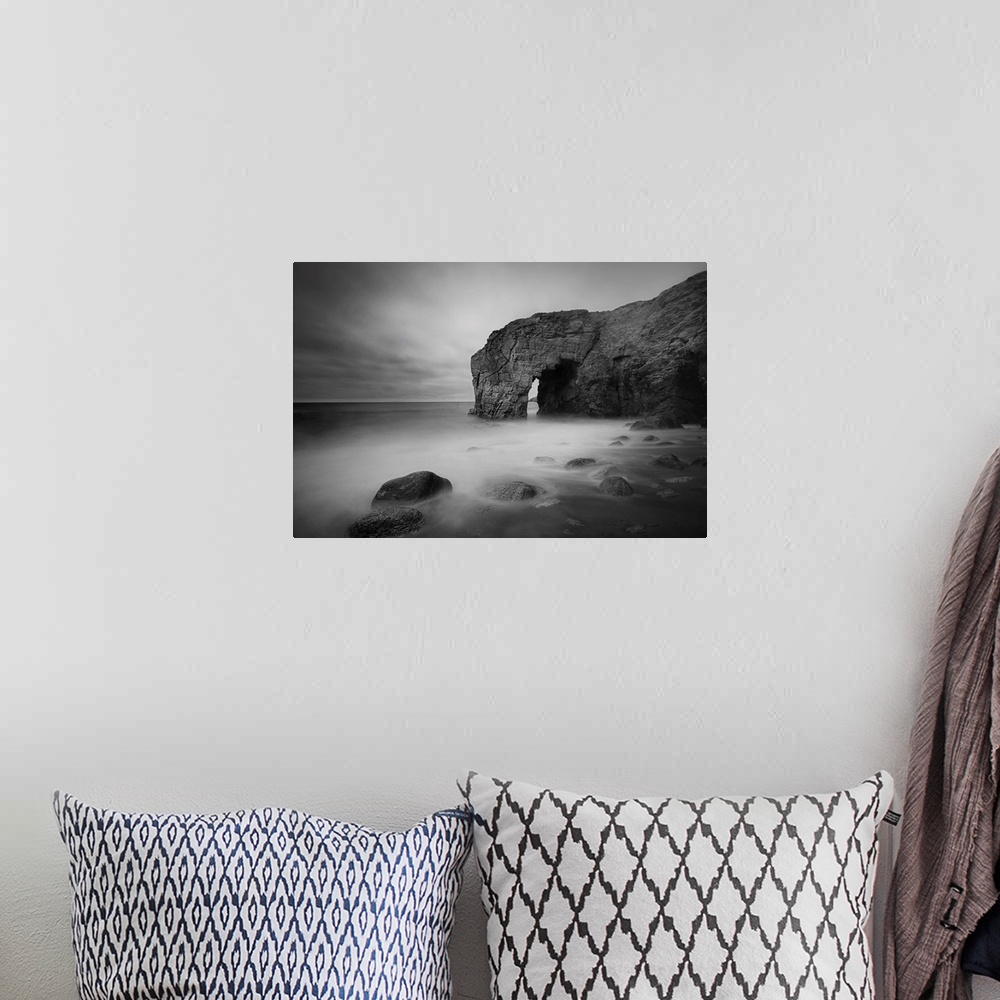 A bohemian room featuring The natural arch rock in Quiberon island in Britany at high tide, a long black and white time exp...