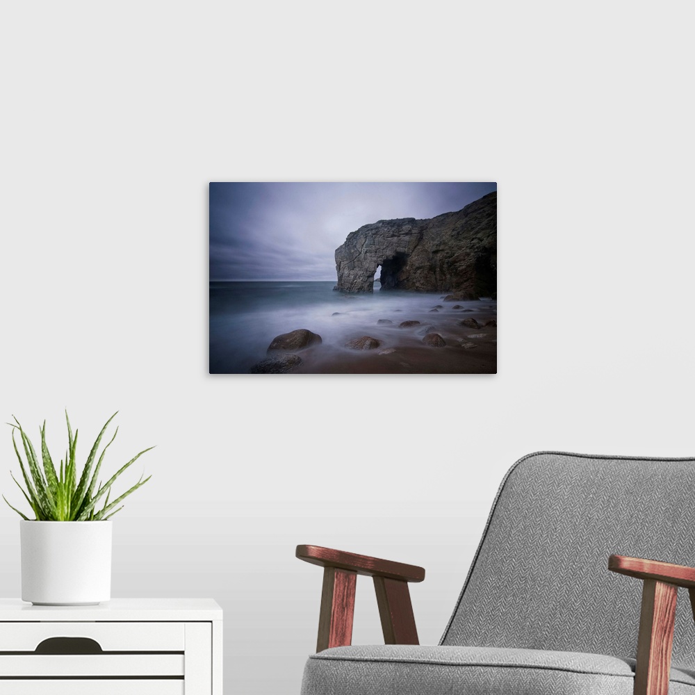 A modern room featuring He natural arch rock in Quiberon island in Britany at high tide, a long colored time exposure, sa...