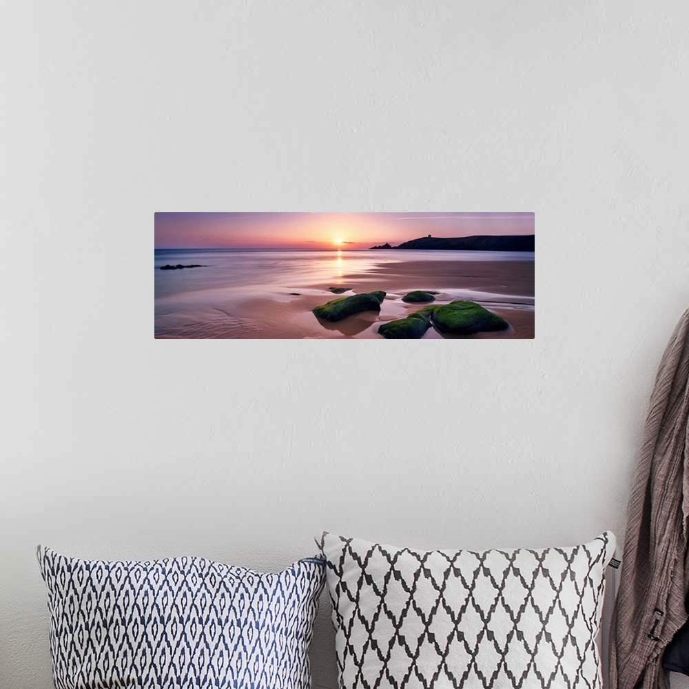 A bohemian room featuring Panoramic beach with rocks during a pink quite sunset in Brittany, France.