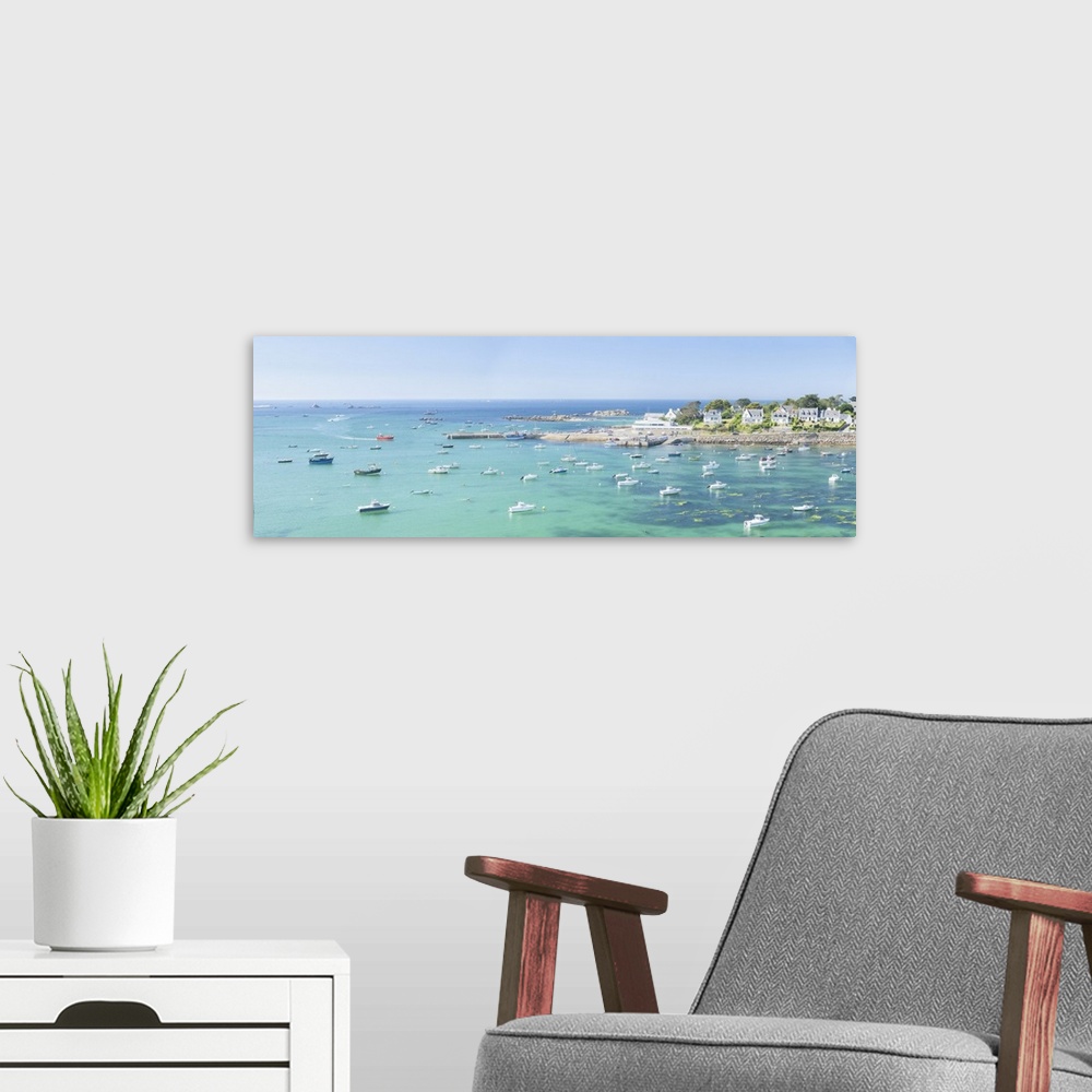 A modern room featuring Panoramic landscape photography of Portsall bay in Brittany with boats and emerald sea on a sunny...