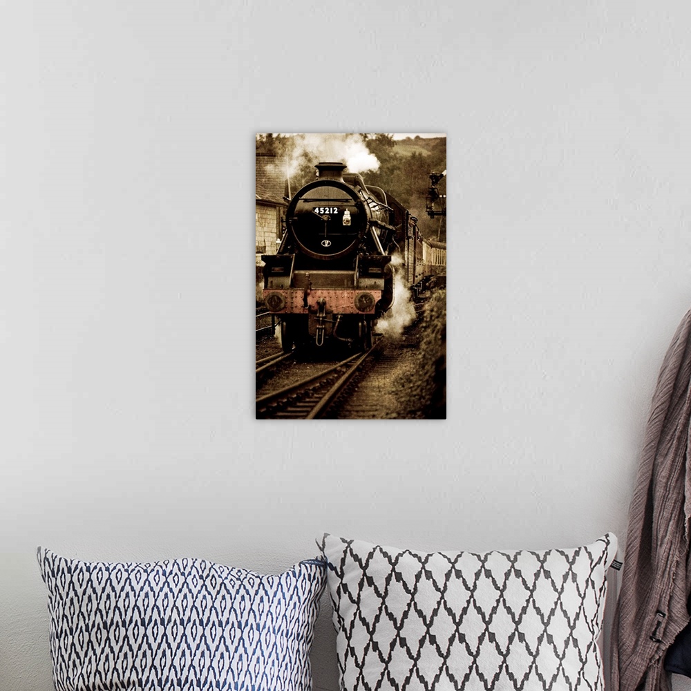 A bohemian room featuring Photograph of front view of locomotive on tracks blowing smoke and pulling into station, with it'...