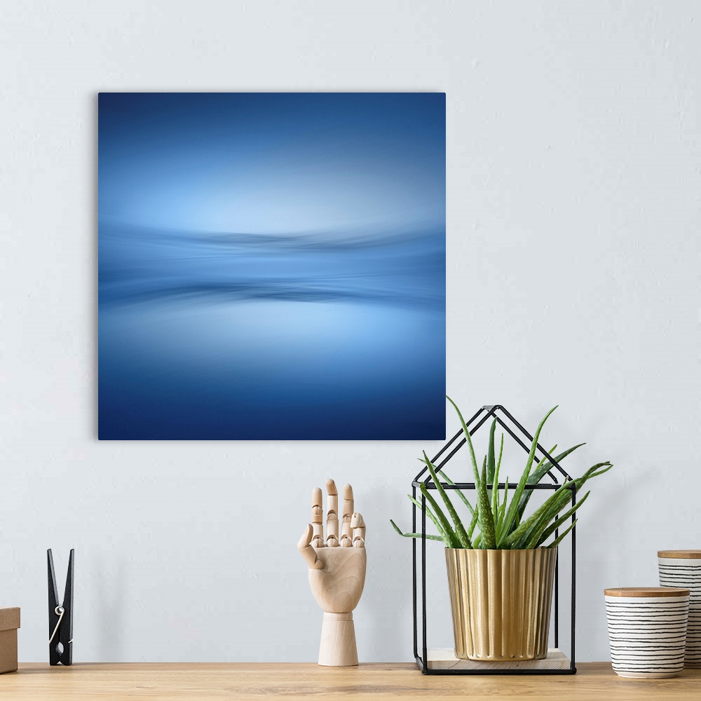 A bohemian room featuring Abstract photograph of a faint horizon line separating a peaceful blue lake and a clear sky.