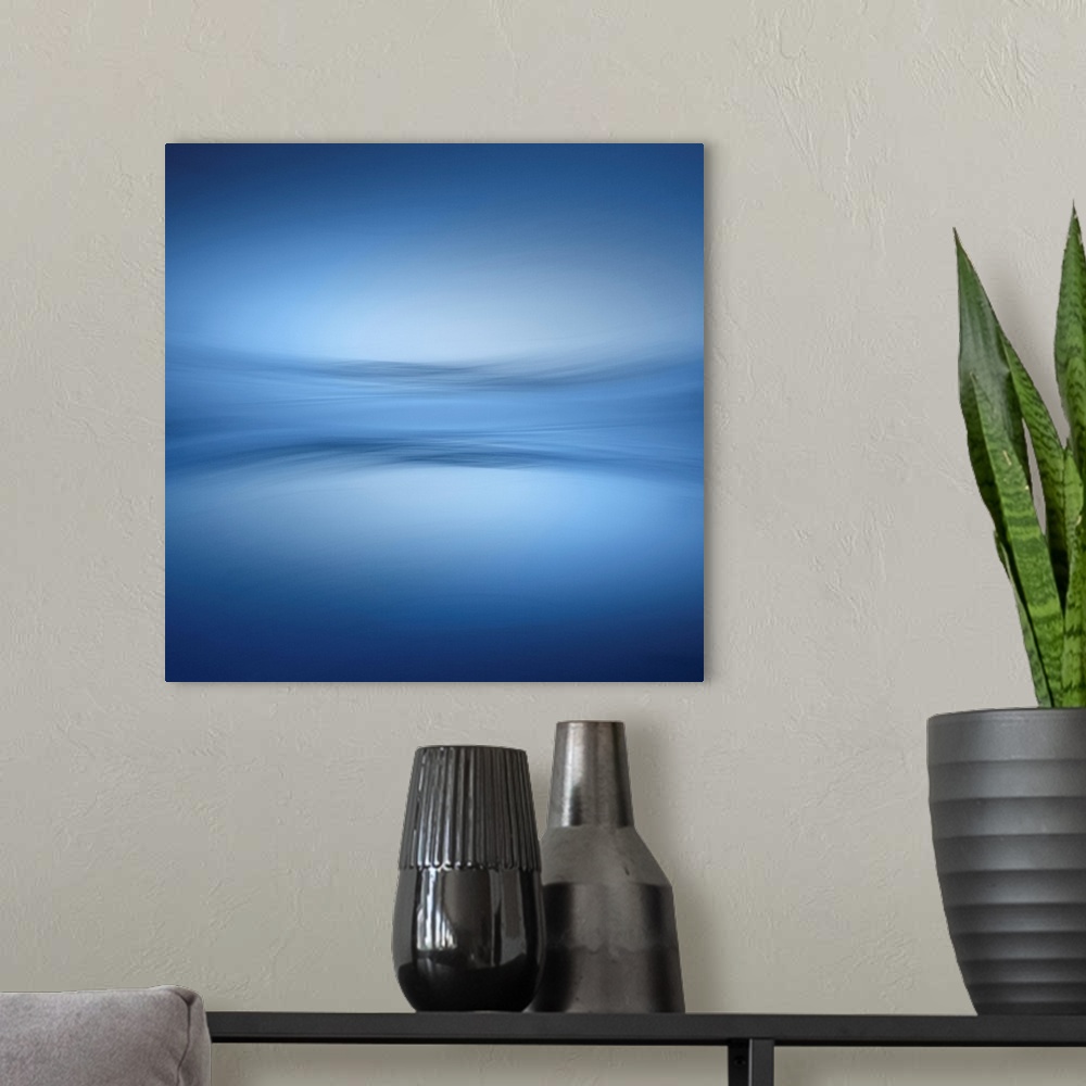 A modern room featuring Abstract photograph of a faint horizon line separating a peaceful blue lake and a clear sky.
