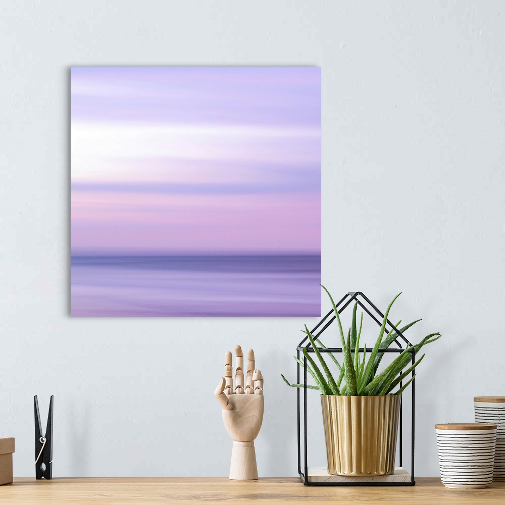 A bohemian room featuring Abstract artwork of a sunset sky over the ocean with a haze over the entire piece to give it a so...