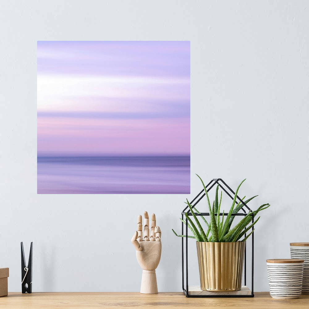 A bohemian room featuring Abstract artwork of a sunset sky over the ocean with a haze over the entire piece to give it a so...