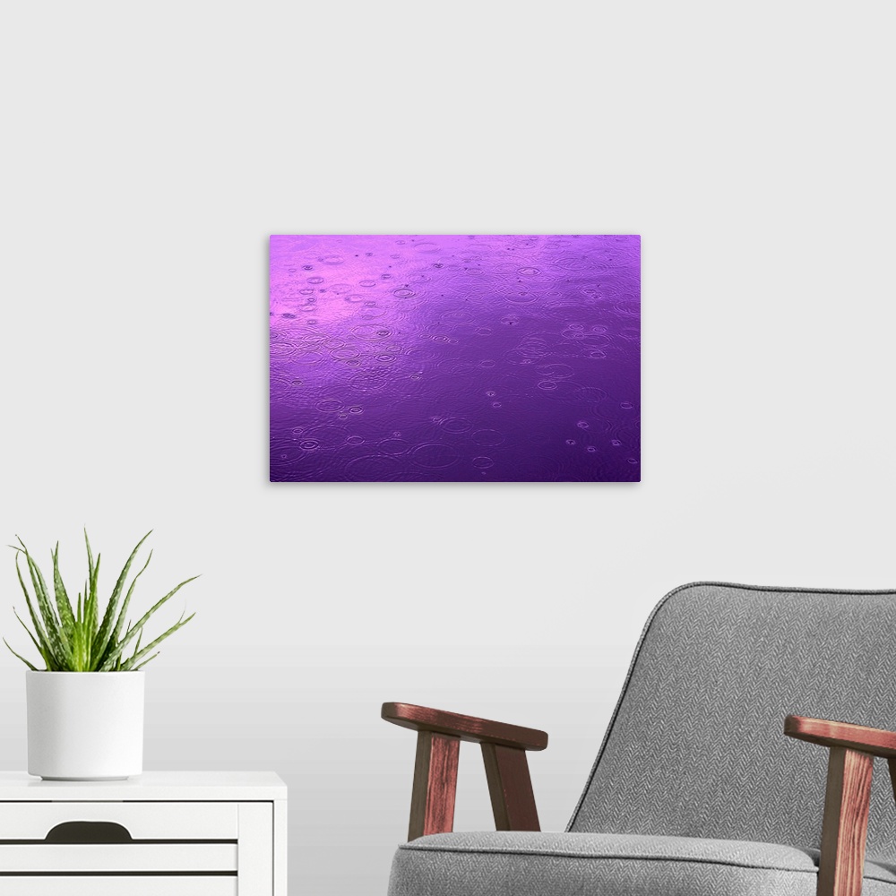 A modern room featuring Abstract photograph of a small lake surface covered in circular ripples from falling raindrops, i...