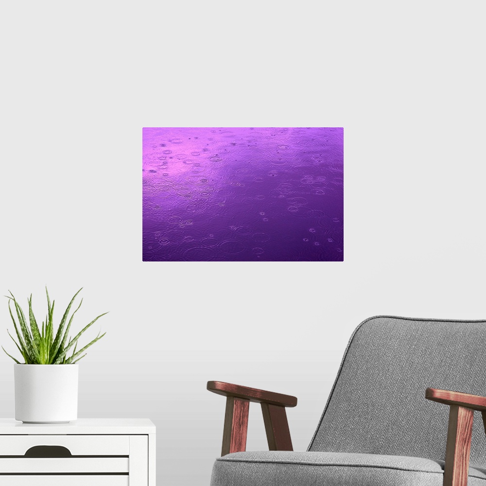 A modern room featuring Abstract photograph of a small lake surface covered in circular ripples from falling raindrops, i...