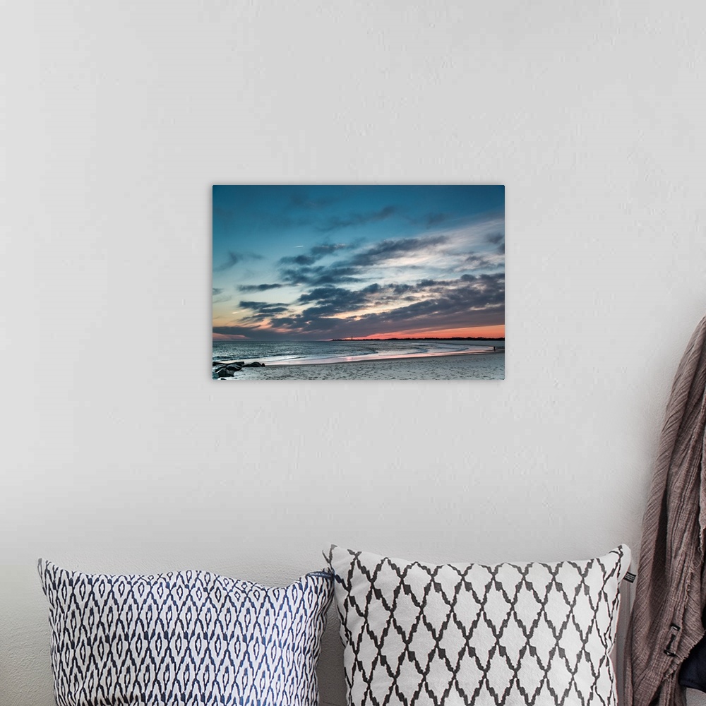 A bohemian room featuring Cloudy skies at sunset over a sandy beach.