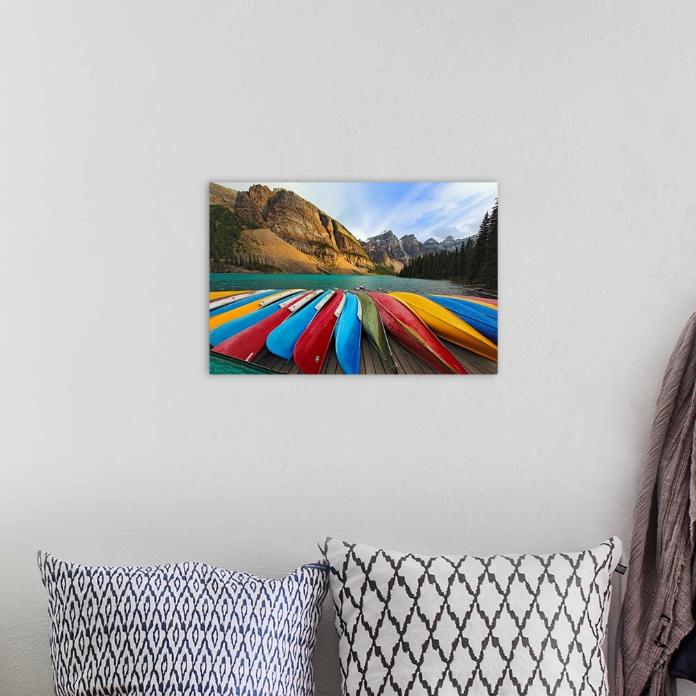 A bohemian room featuring Large, horizontal photograph of colorful boats lined up on a dock at Moraine Lake.  The mountains...