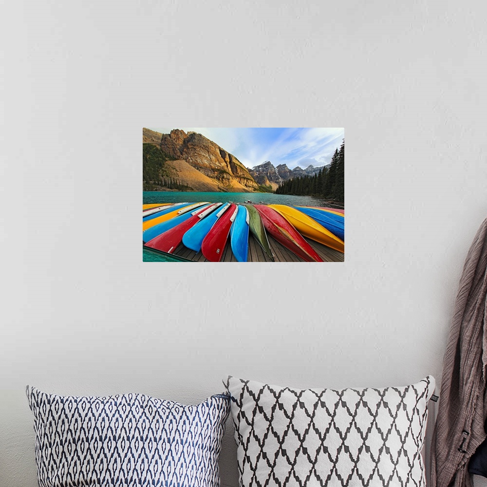 A bohemian room featuring Large, horizontal photograph of colorful boats lined up on a dock at Moraine Lake.  The mountains...