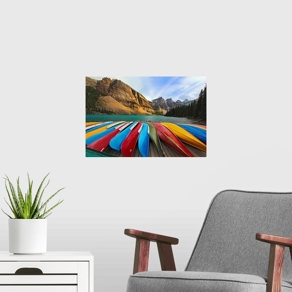 A modern room featuring Large, horizontal photograph of colorful boats lined up on a dock at Moraine Lake.  The mountains...