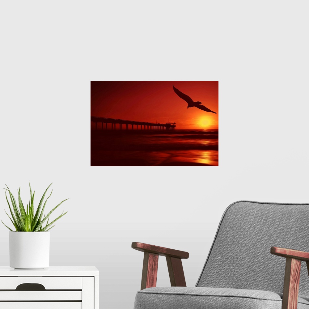 A modern room featuring The sun setting fills this piece with warm tones throughout and a long pier stretches out into th...