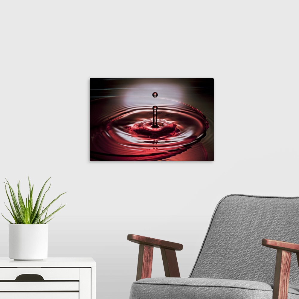 A modern room featuring A macro photograph of a water droplet suspended in air after hitting a watery surface.