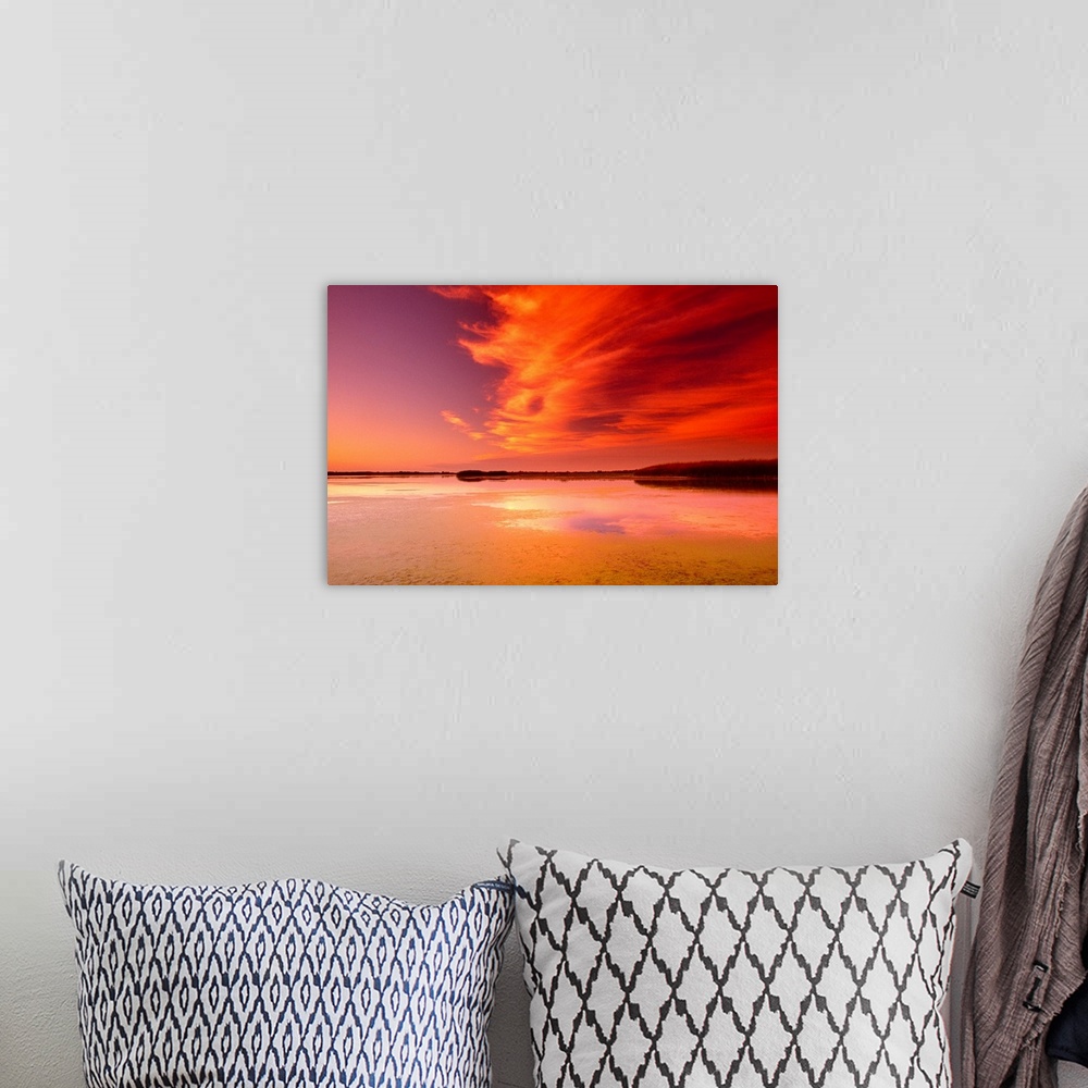 A bohemian room featuring Sunset over marsh with wispy clouds overhead.