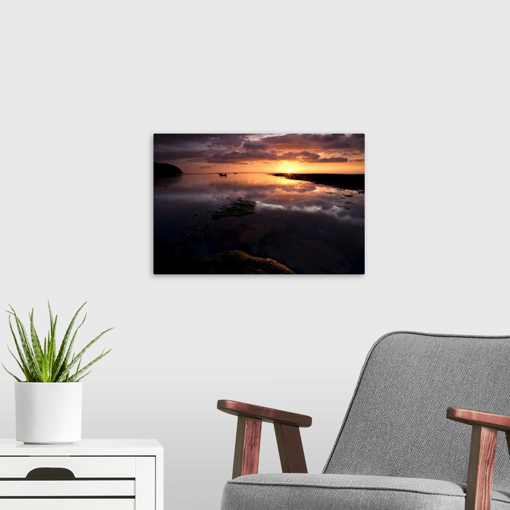 A modern room featuring A Beautiful warm golden sunrise over reflecting wet sand with dramatic clouds.