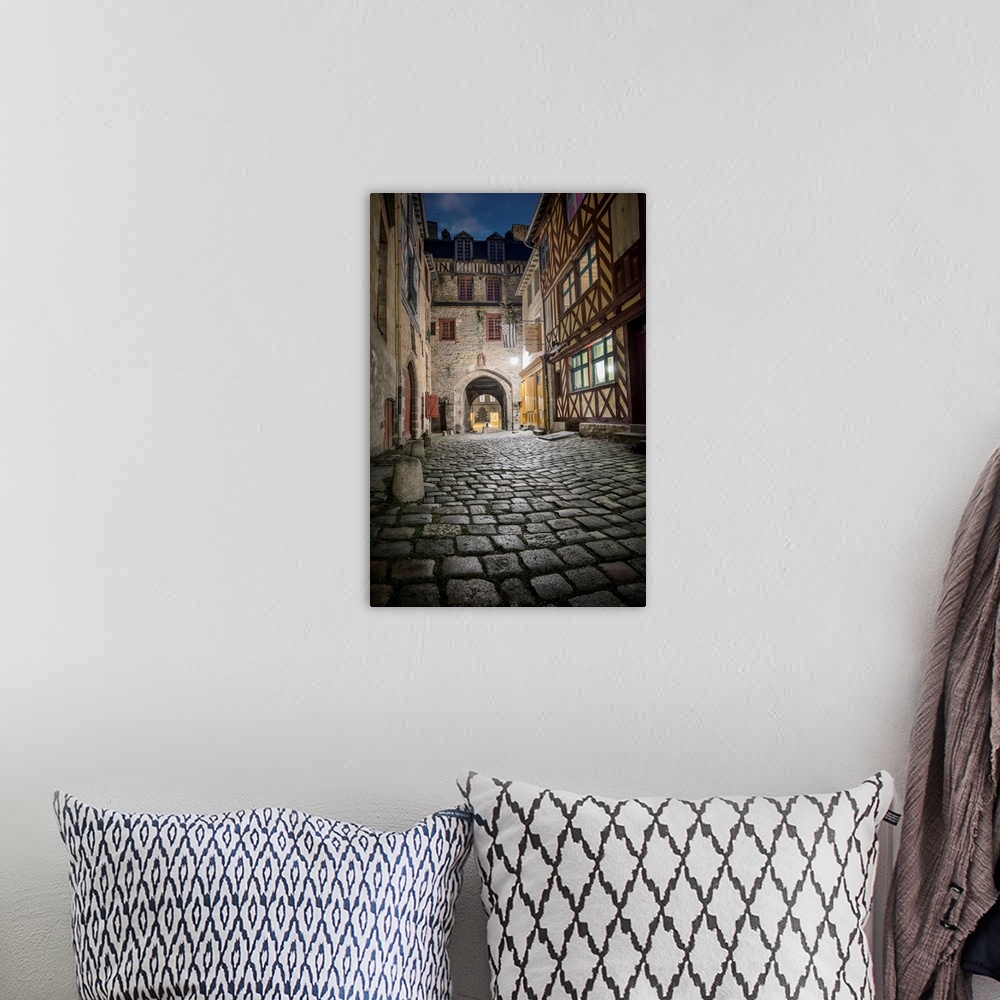 A bohemian room featuring A photograph looking down the road of a French village.