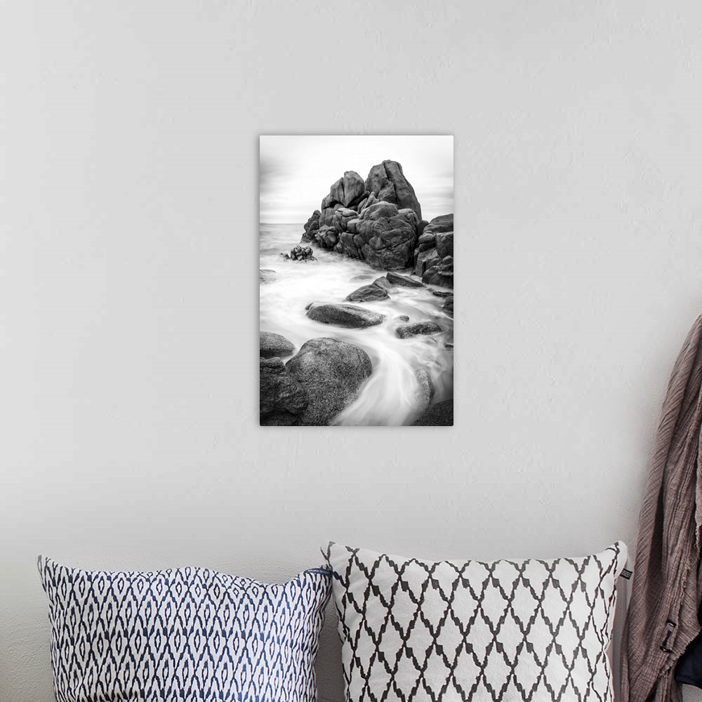 A bohemian room featuring A black and white photograph of a rocky coastline.