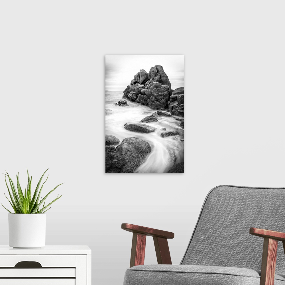 A modern room featuring A black and white photograph of a rocky coastline.