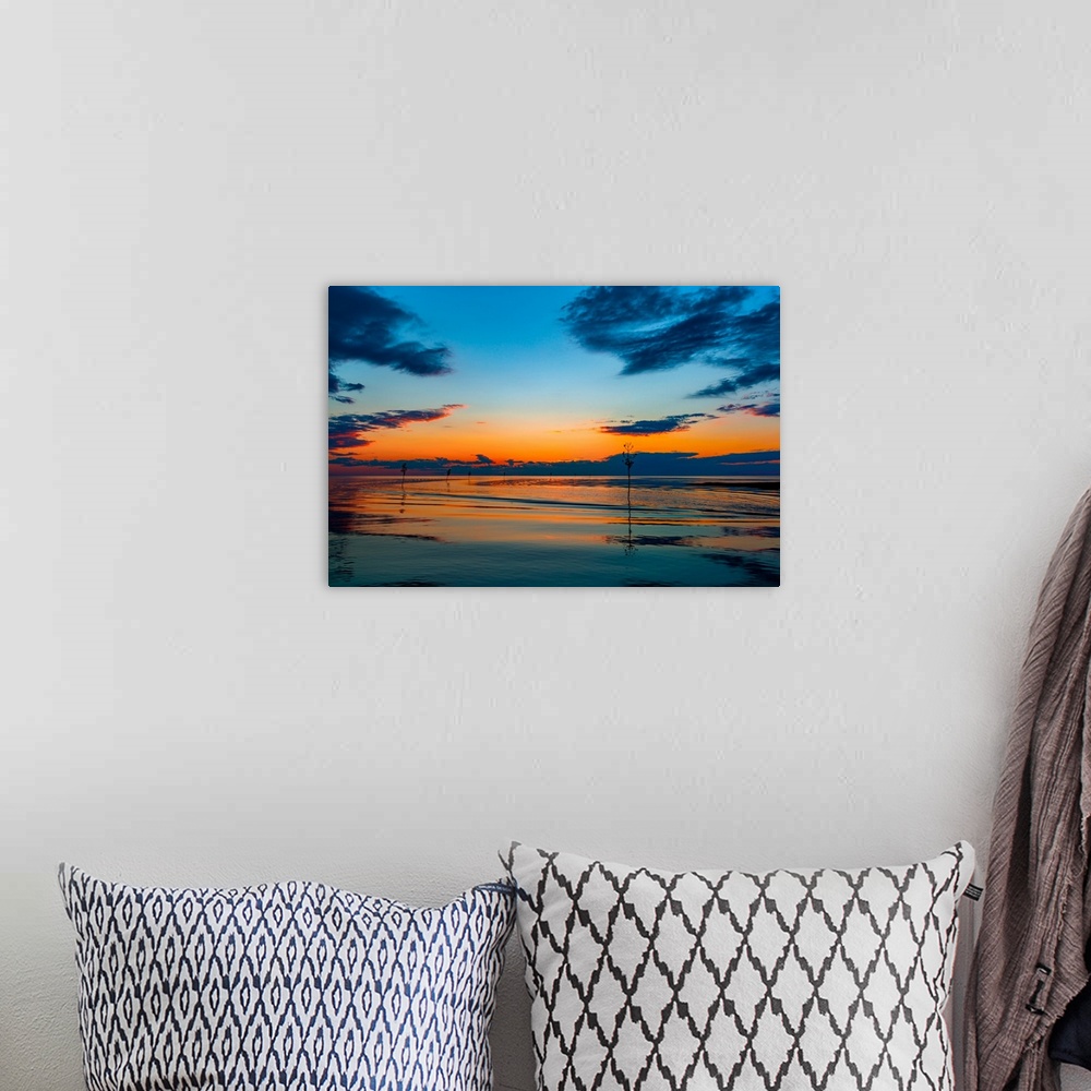 A bohemian room featuring Boats on calm waters under a colorful sunset in shades of orange and blue.