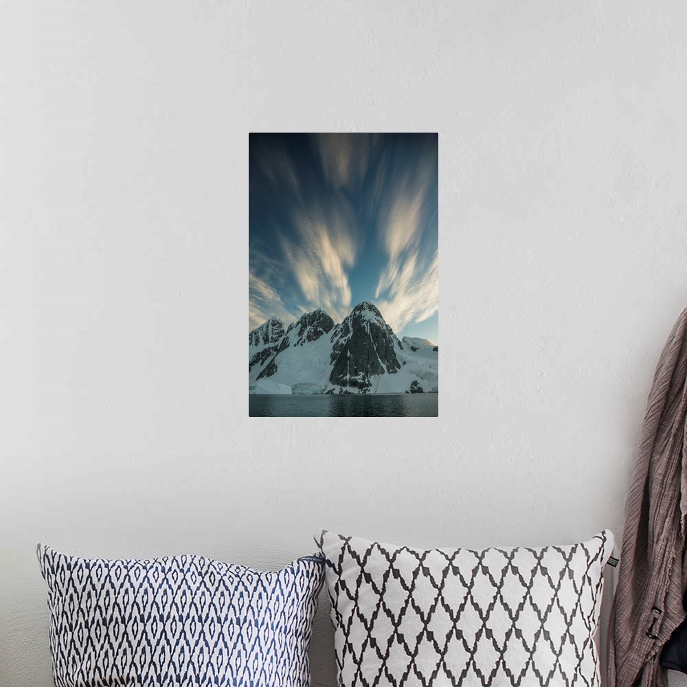 A bohemian room featuring Clouds rushing by overhead of snowy mountain scape.