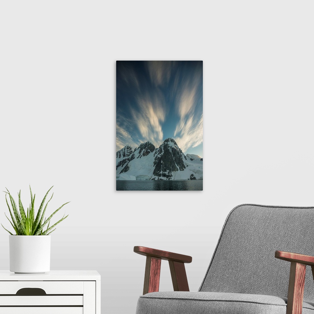 A modern room featuring Clouds rushing by overhead of snowy mountain scape.