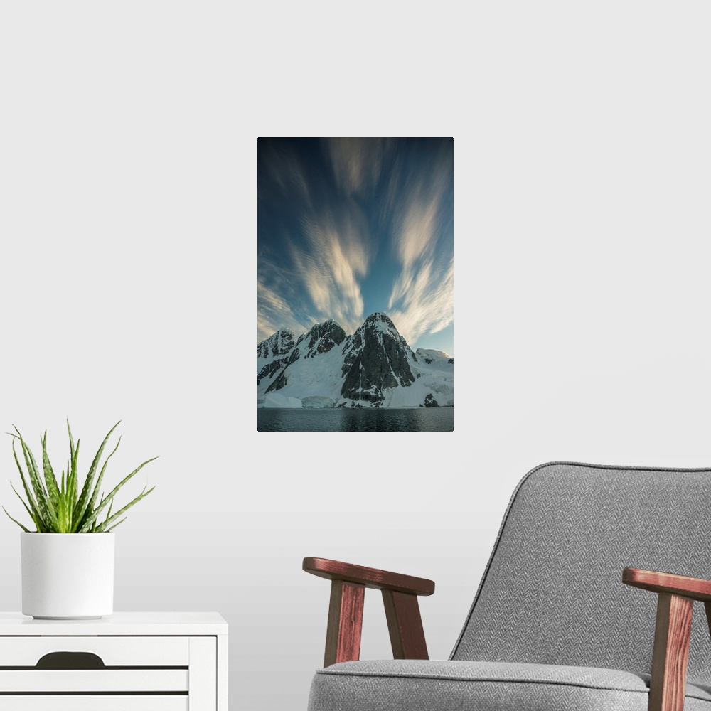 A modern room featuring Clouds rushing by overhead of snowy mountain scape.