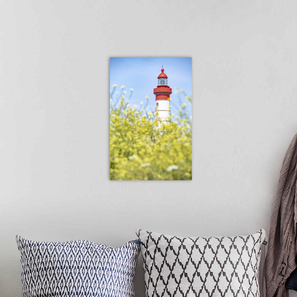 A bohemian room featuring Saint Mathieu red and white lighthouse under a blue sky and behind yellow flowers in Brittany.Por...