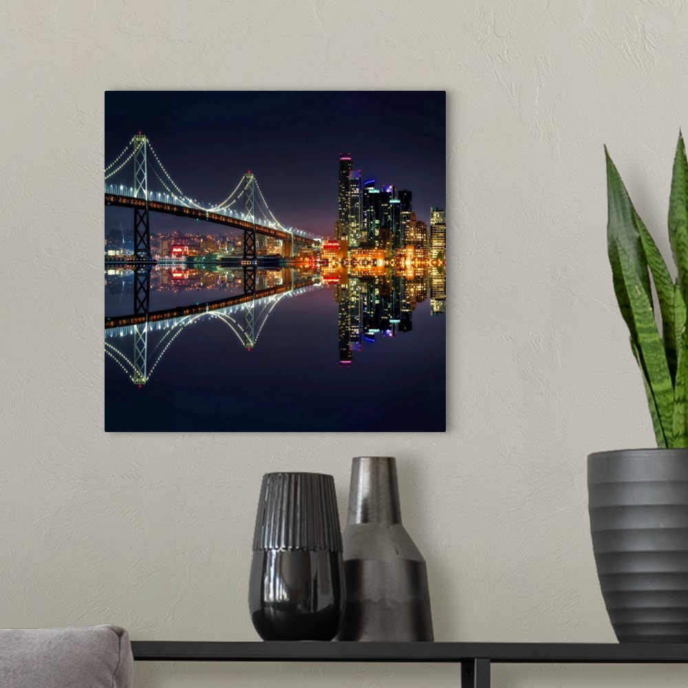 A modern room featuring Square photograph of the Bay Bridge and downtown San Francisco lit up at night and reflecting ont...