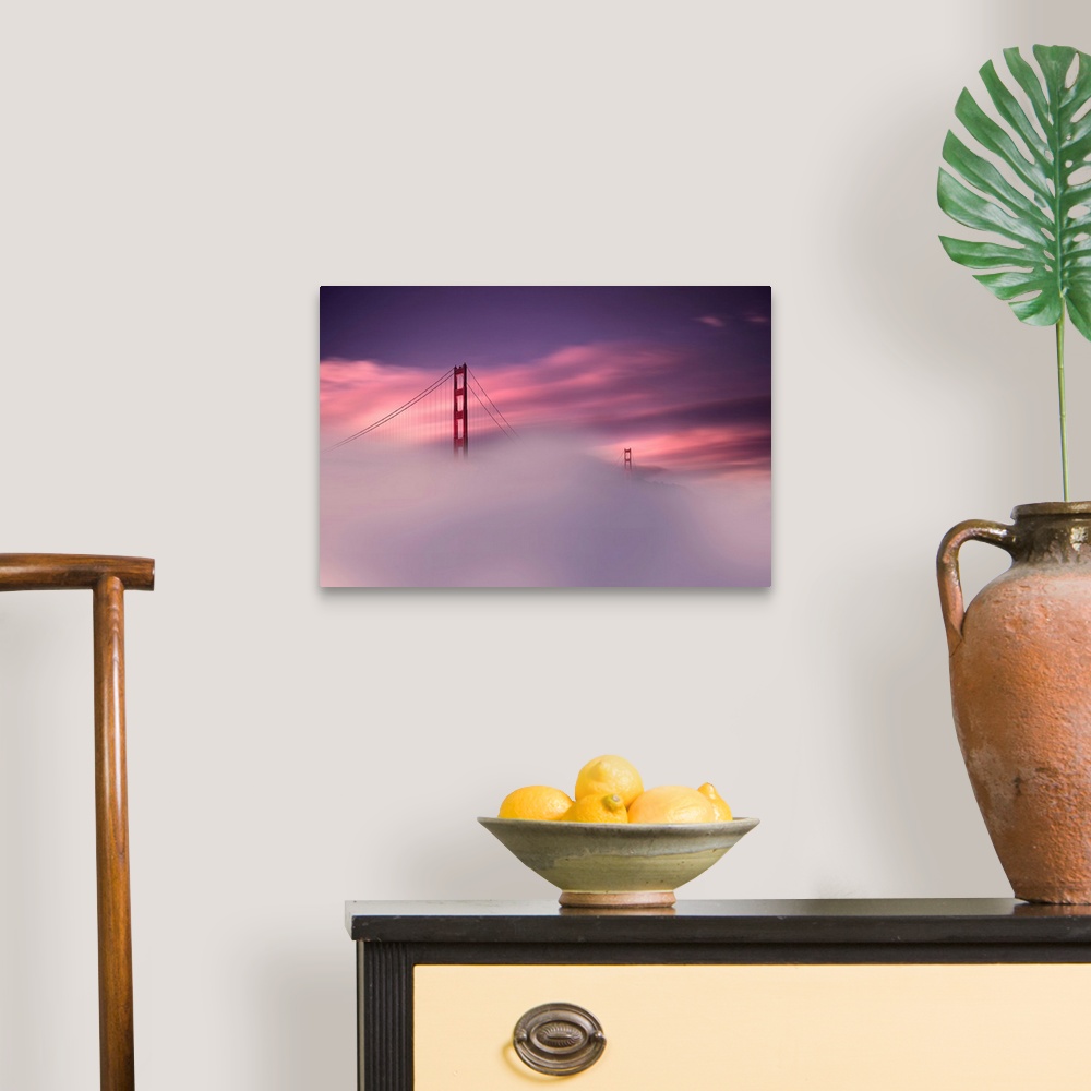 A traditional room featuring A sunset obscured by dense fog and the Golden Gate Bridge rising out of the mist in this landscap...