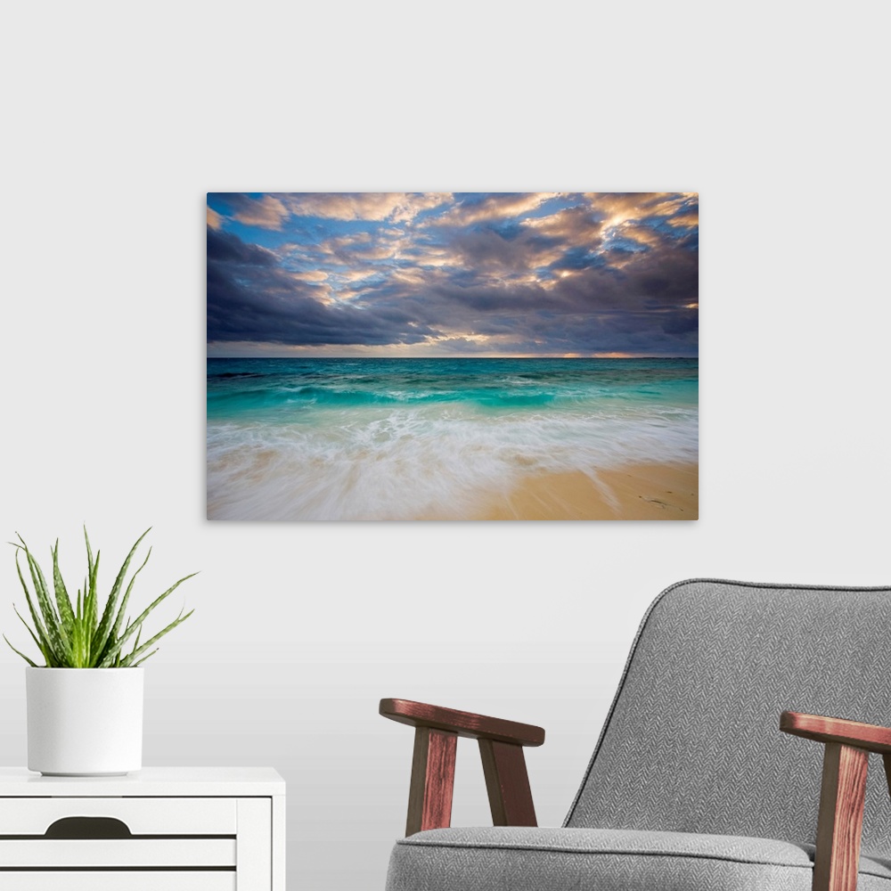 A modern room featuring A giant photograph of a beach on the Ambergris Cay Island within the Turks and Caicos Islands.  T...