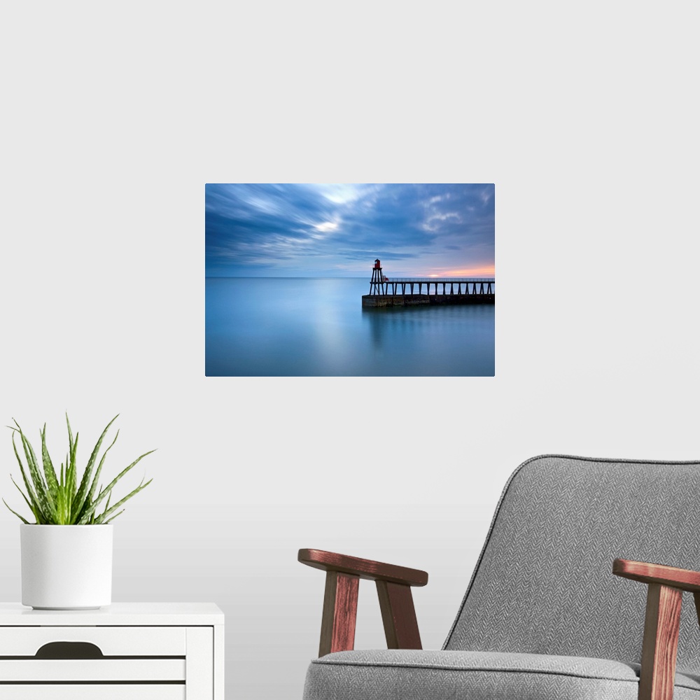 A modern room featuring Timeless blue dawn over flat sea with scudding clouds and a lighthouse jetty.