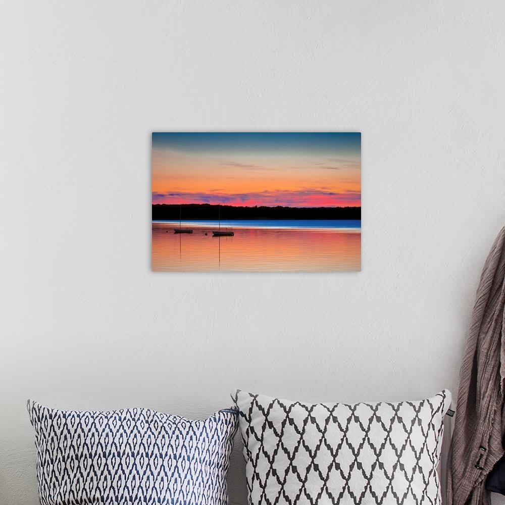 A bohemian room featuring Two boats on calm waters under a colorful sunset in shades of pink, orange, and blue.