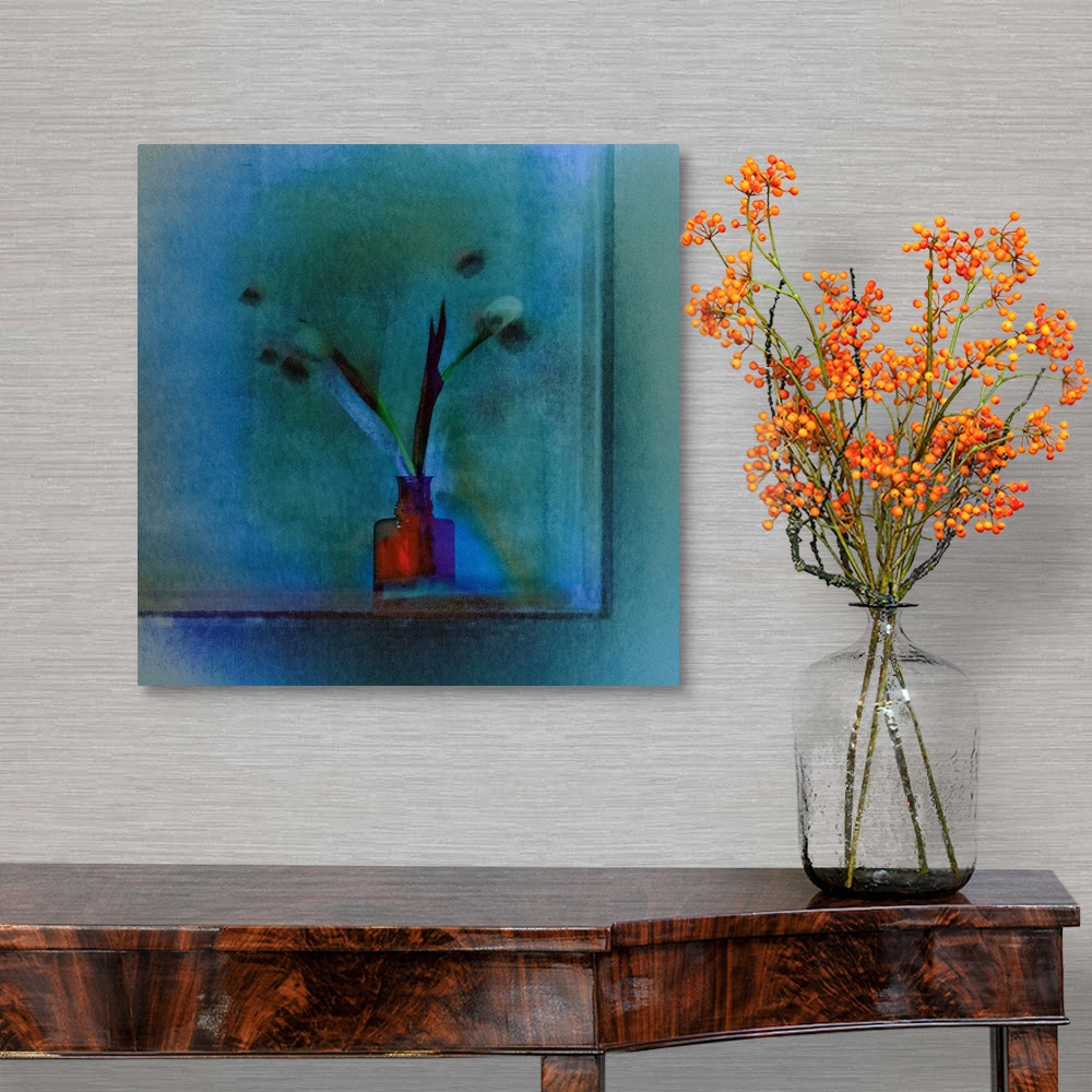 A traditional room featuring Square image of a bright red vase with long stemmed tulips on a blue background.