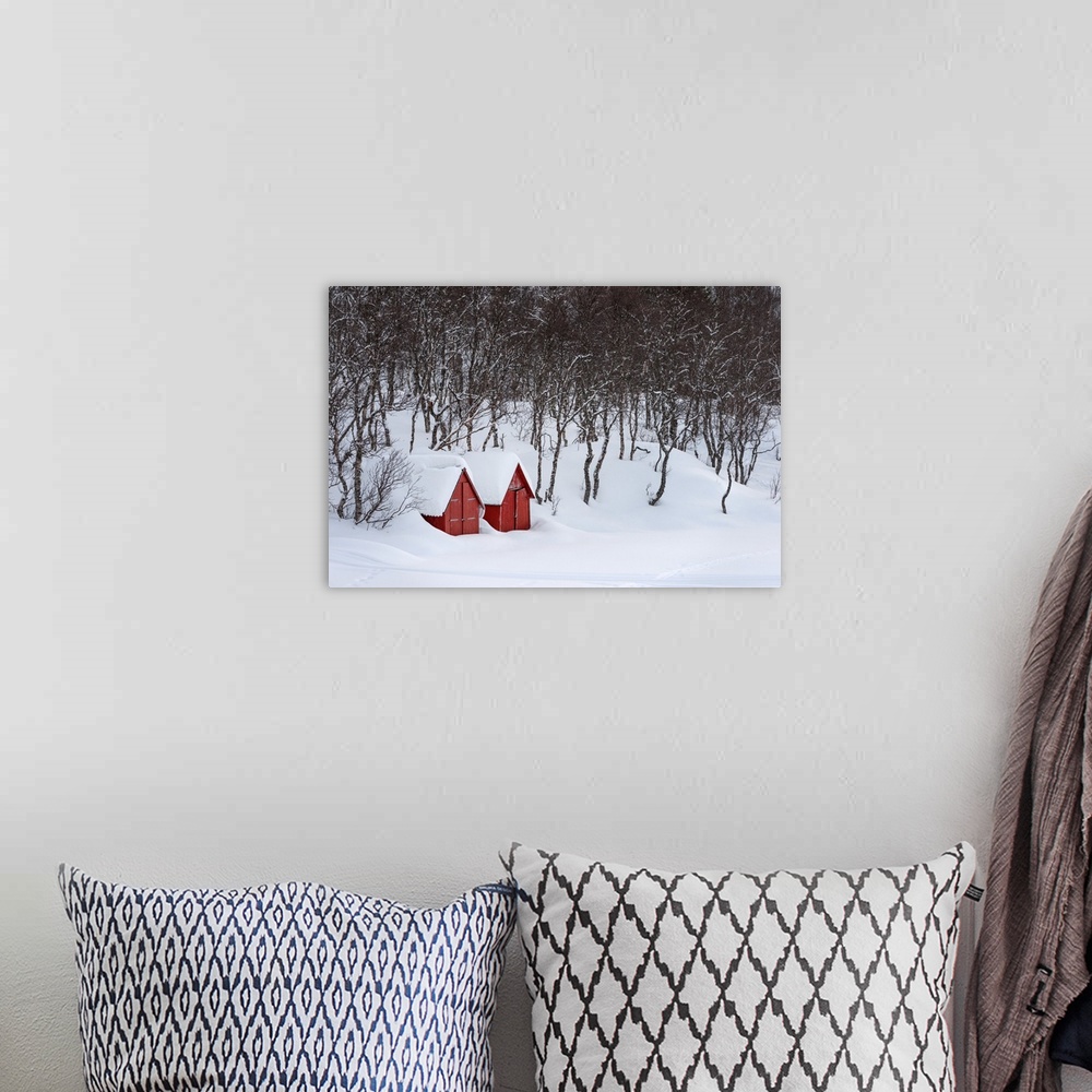 A bohemian room featuring A photograph of two red houses under a thick blanket of snow.
