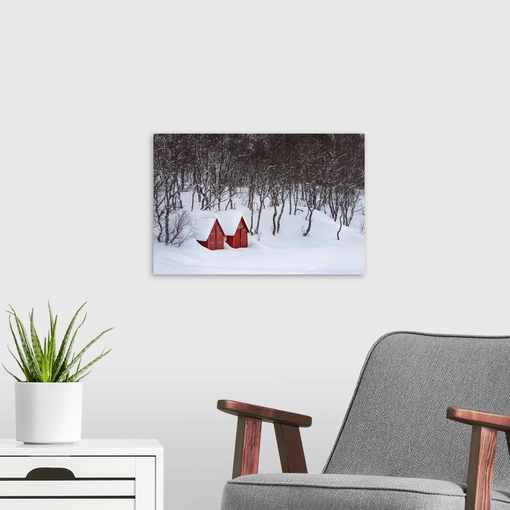 A modern room featuring A photograph of two red houses under a thick blanket of snow.