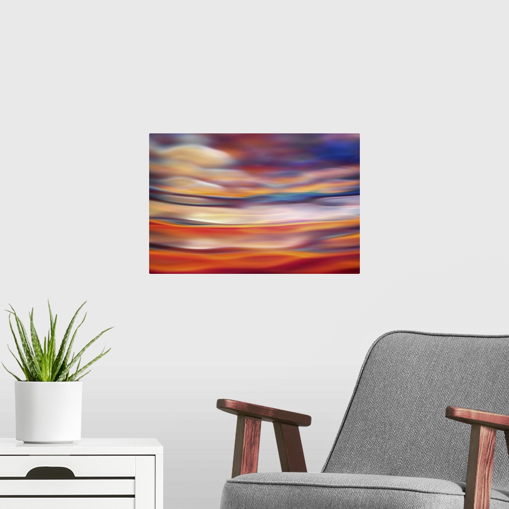 A modern room featuring Abstract photograph in orange and red shades resembling ocean waves.