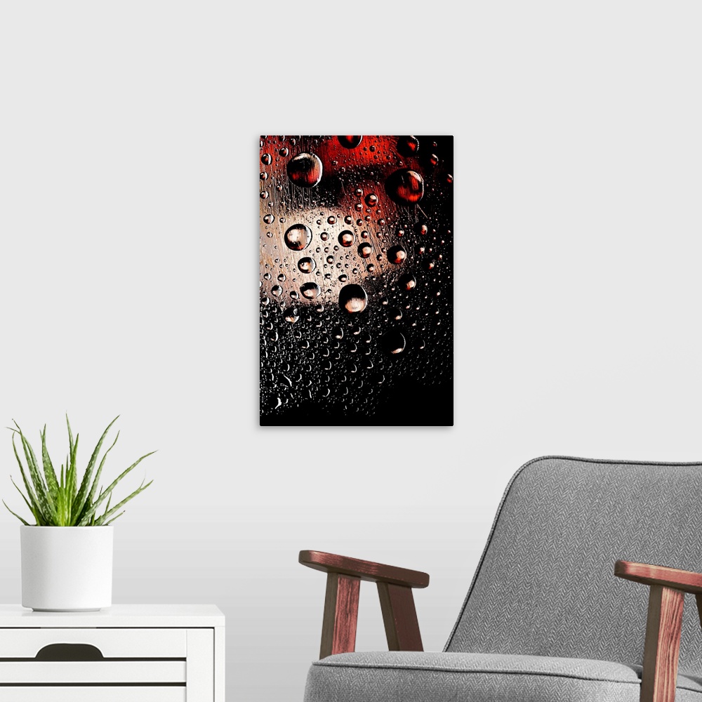 A modern room featuring A photo of raindrops sitting on a window with red and white lights shining behind.