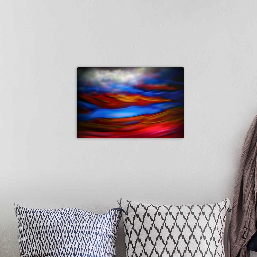 A bohemian room featuring Abstract photograph in red and blue shades resembling ocean waves.