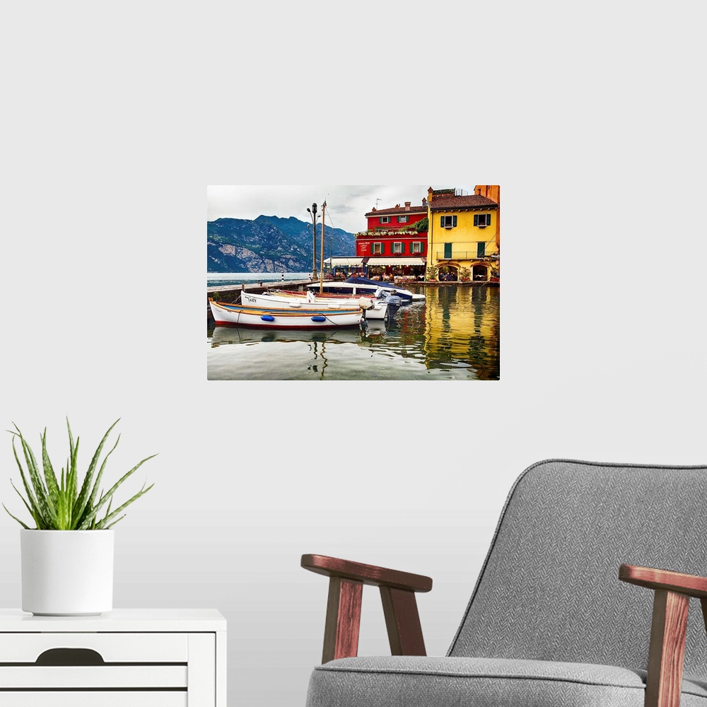 A modern room featuring Fine art photo of boats docked in a harbor near brightly painted houses in Italy.