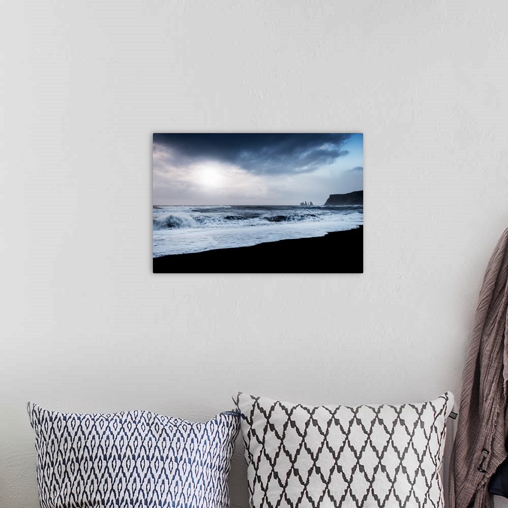 A bohemian room featuring A photograph of a dark rugged coastline.